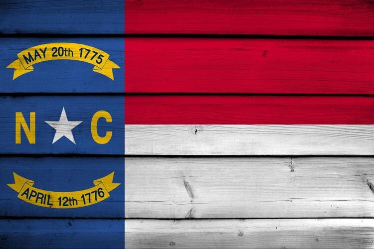 Sello de Carolina del Norte sobre fondo de madera con colores de la bandera de EE. UU.